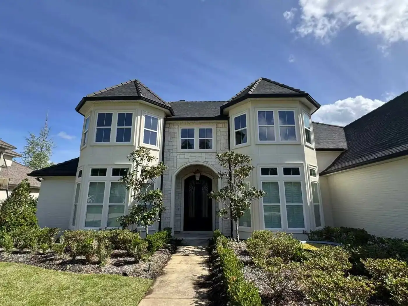 Symmetrical estate facade with twin bay-window turrets flanking a central arched entryway